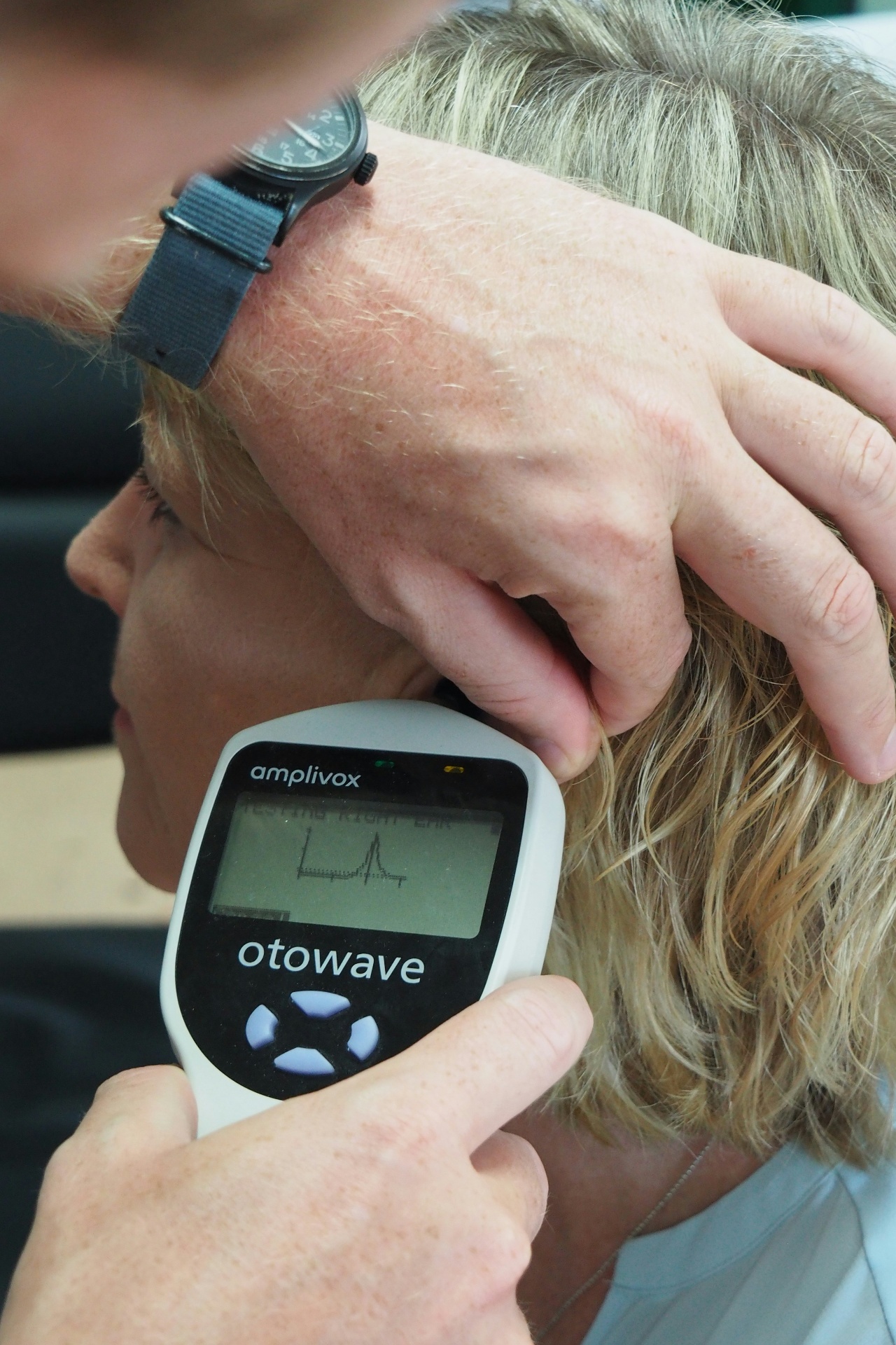 An audiologist discussing tinnitus symptoms with a patient during a hearing assessment