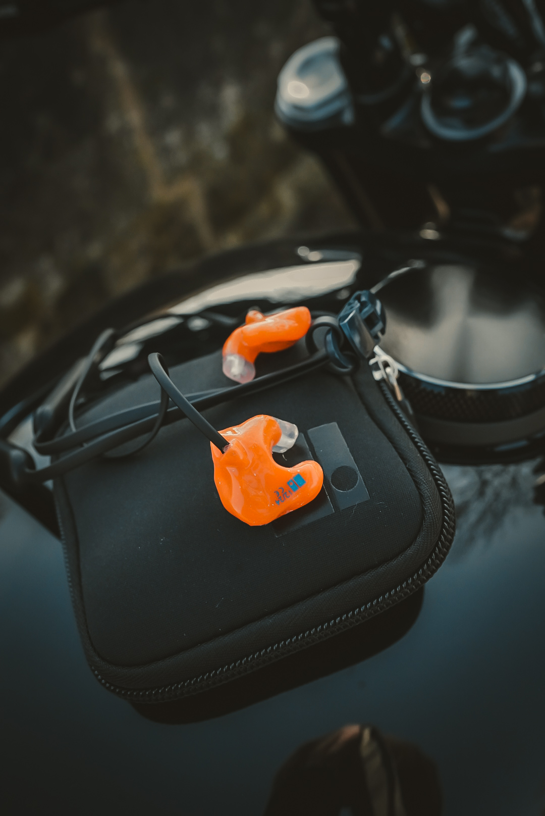 Orange custom-moulded earplugs personalised with engraved initials