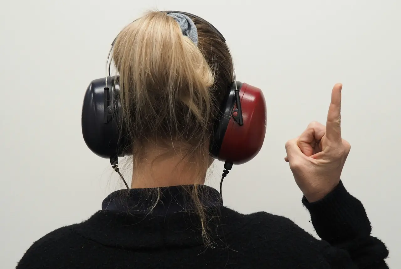 A patient wearing audiometric headphones while an audiologist carries out a hearing assessment