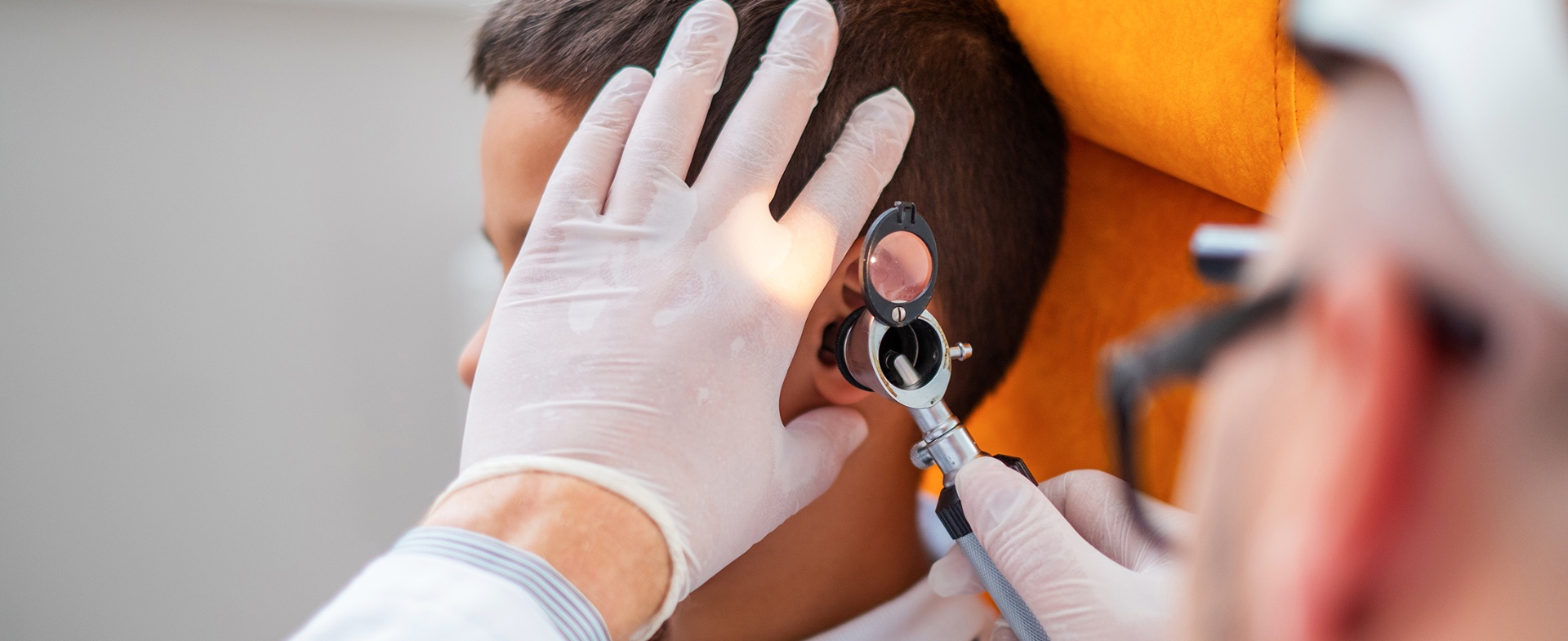An audiologist gently examining a child's ear with an otoscope at our Kenfig Hill, Bridgend clinic